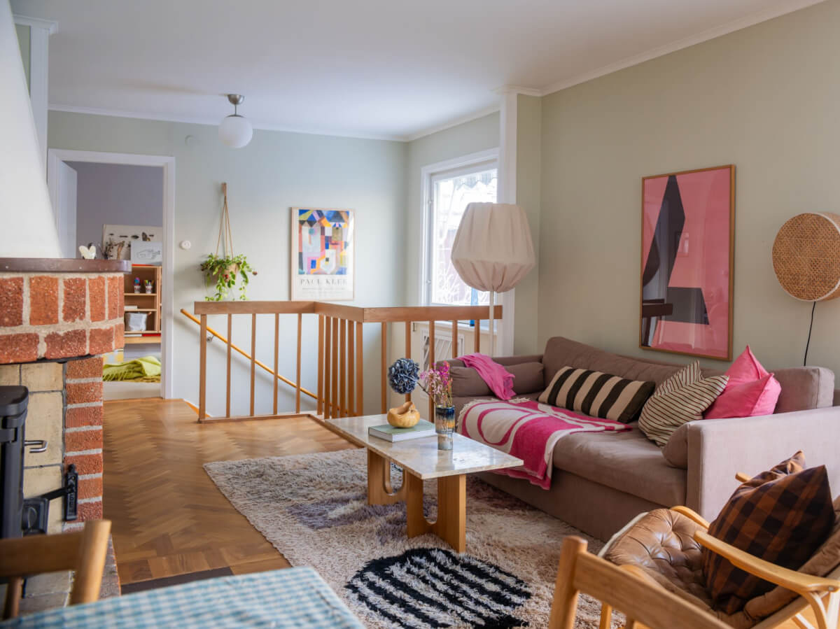 A Beautiful Midcentury Family Home South of Stockholm 15 living room with brick fireplace and pink color accents