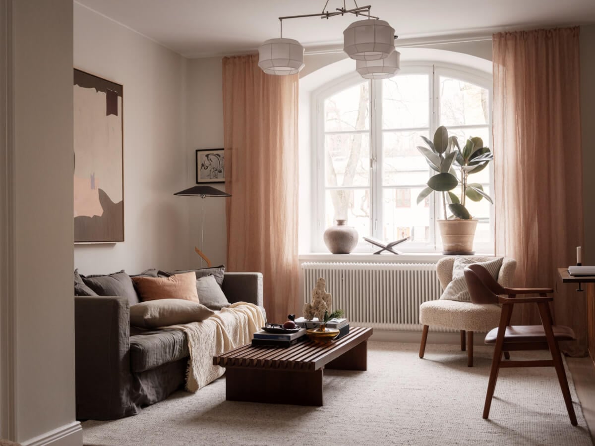 A Calm and Contemporary Apartment in a Former Office Space 4 living room with large arched window and terracotta curtains