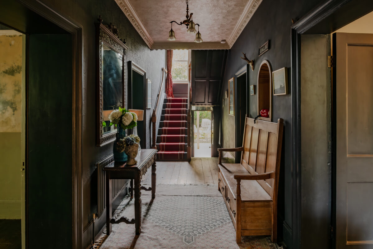 A Strong Color Palette in a Unique Country House in Cornwall 12 moody historic hallway with antique wooden bench