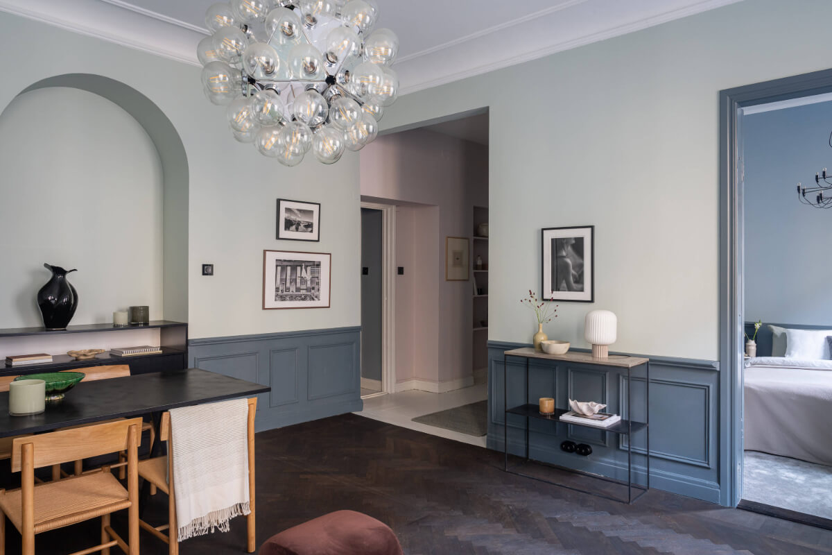 A Moody Color Palette in a Stylish One-Bedroom Apartment in Stockholm 14 muted living room with open floor plan to hall