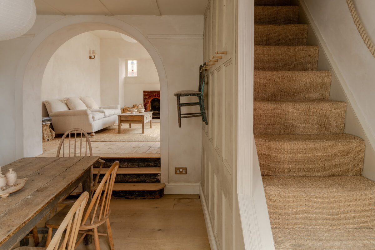 A Light Rustic Farmhouse-Style in an English Cottage 9 open plan living space with arched opening and staircase nordroom