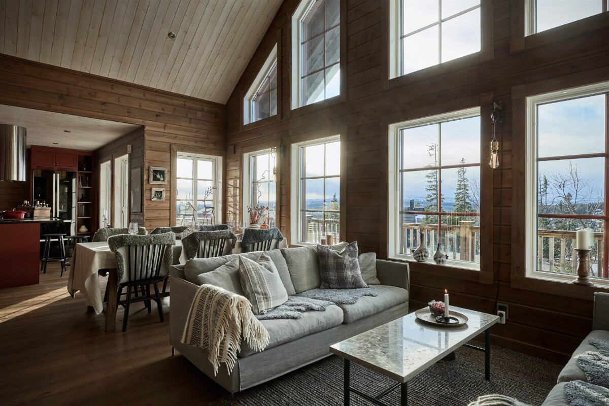 A Warm and Inviting Mountain House in Sweden 4 open plan log house living room with pitched ceiling and large windows A Warm and Inviting Mountain House in Sweden