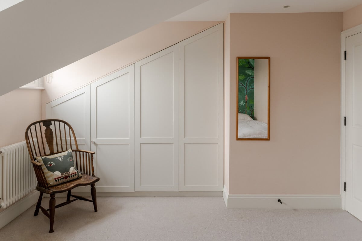 A Beautiful Extended Victorian Family Home in London 19 pink bedroom with wardrobes fitted under the slanted ceiling nordroom