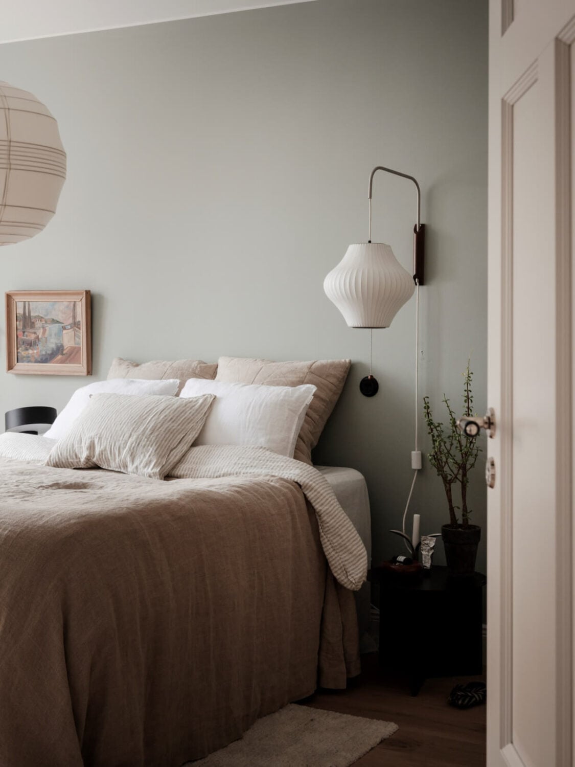 A Calm and Contemporary Apartment in a Former Office Space 15 scandi bedroom with large wall lamp and neutral bedding