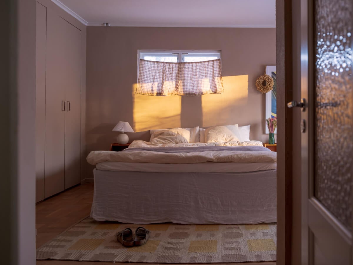 A Beautiful Midcentury Family Home South of Stockholm 18 serene bedroom with evening light flooding in