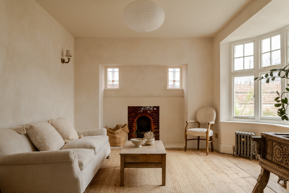 serene living room with bay window plaster walls and brick fireplace nordroom