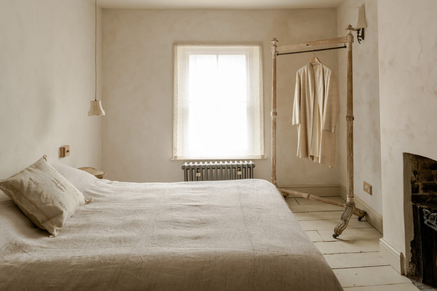 A Light Rustic Farmhouse-Style in an English Cottage 18 serene minimalistic bedroom with plaster walls and fireplace nordroom
