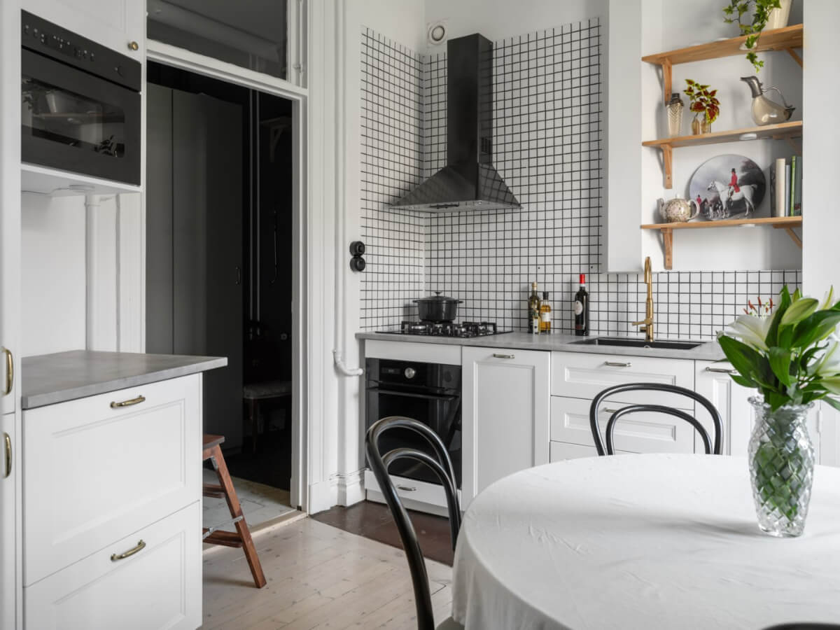 A Classic Studio Apartment with an Industrial Glass Room Divider 13 small classic style white kitchen with round dining table
