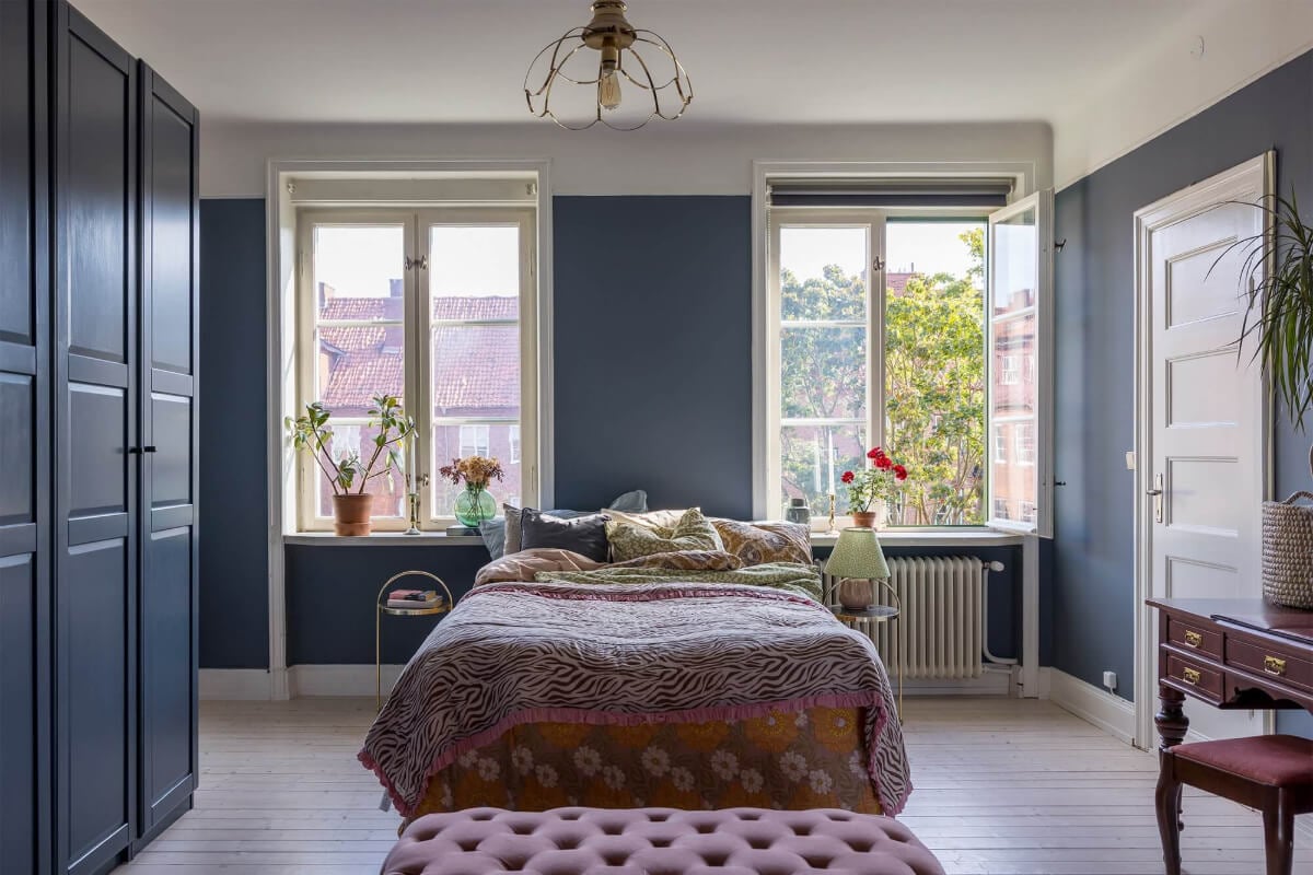 A Spacious Nordic Apartment with a Wonderful Color Palette 13 spacious dark blue bedroom with antique desk and blue wardrobes nordroom