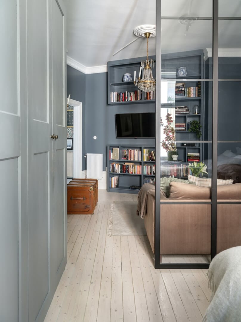 A Classic Studio Apartment with an Industrial Glass Room Divider 7 studio apartment with dark blue walls and gray wardrobes nordroom