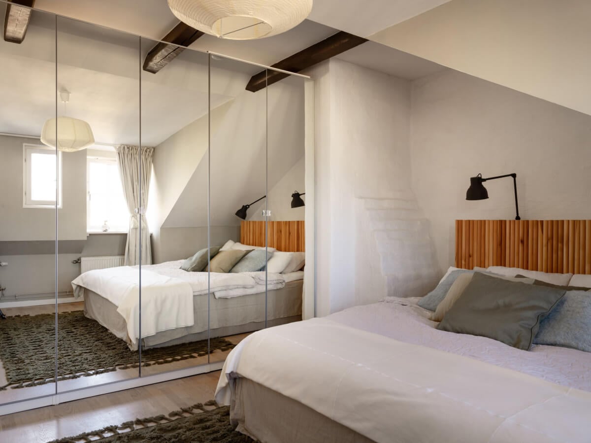 A Charming Light-Filled Attic Apartment with a Dark Oak Kitchen 16 swedish bedroom with built in wardrobes mirror doors