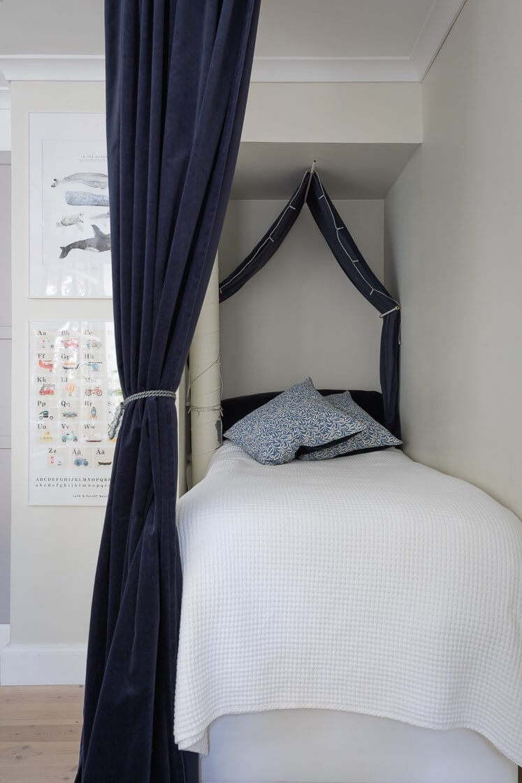 A Small and Bright Two-Bedroom Apartment in Stockholm 9 tiny bed niche with blue velvet curtains