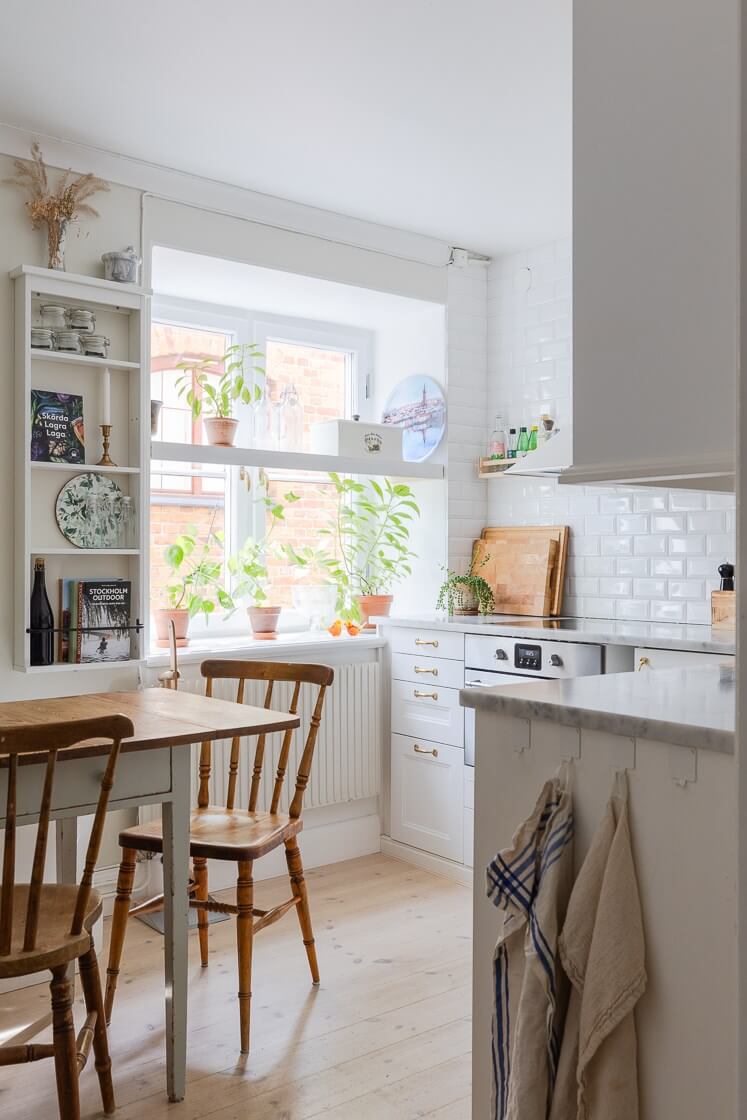 A Small and Bright Two-Bedroom Apartment in Stockholm 12 tiny kitchen with white cabinet and brass fittings