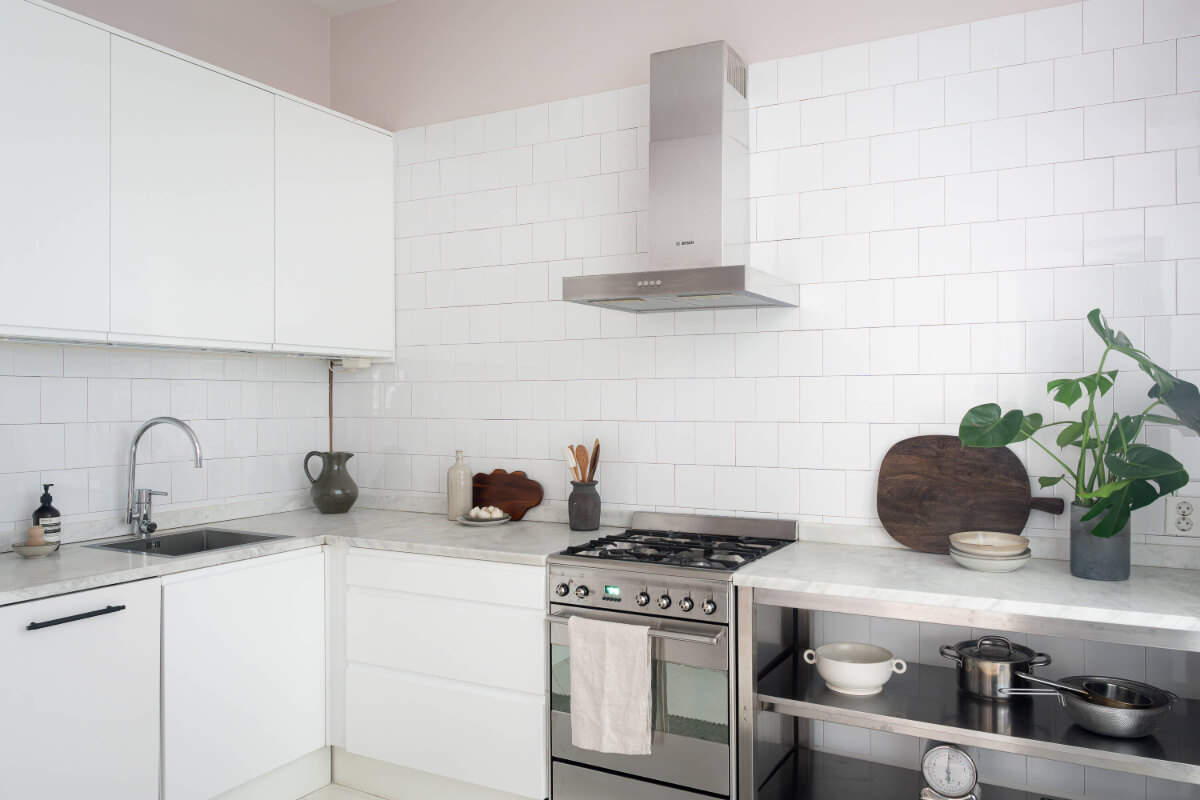 A Moody Color Palette in a Stylish One-Bedroom Apartment in Stockholm 16 white kitchen with marble countertop