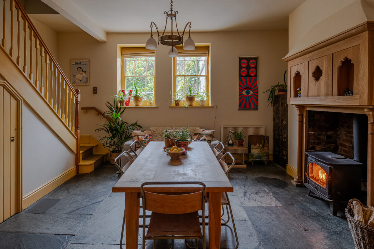 A Strong Color Palette in a Unique Country House in Cornwall 10 yellow dining room with stone floor and log burner nordroom