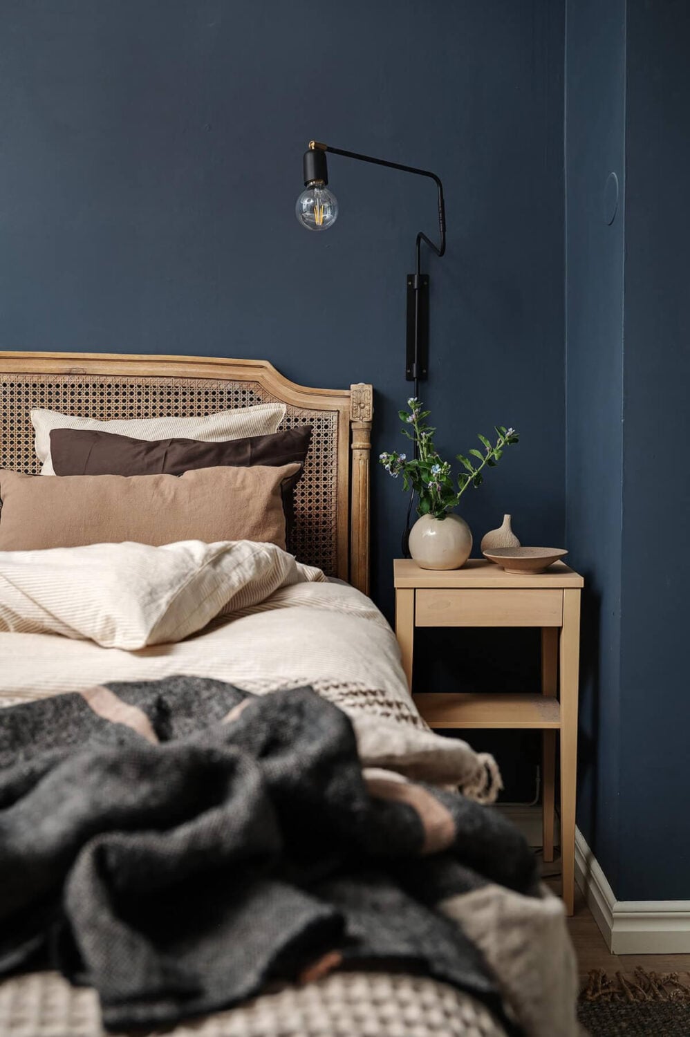 Warm and Inviting Rooms in a Renovated Swedish Apartment 20 antique cane headboard dark blue bedroom