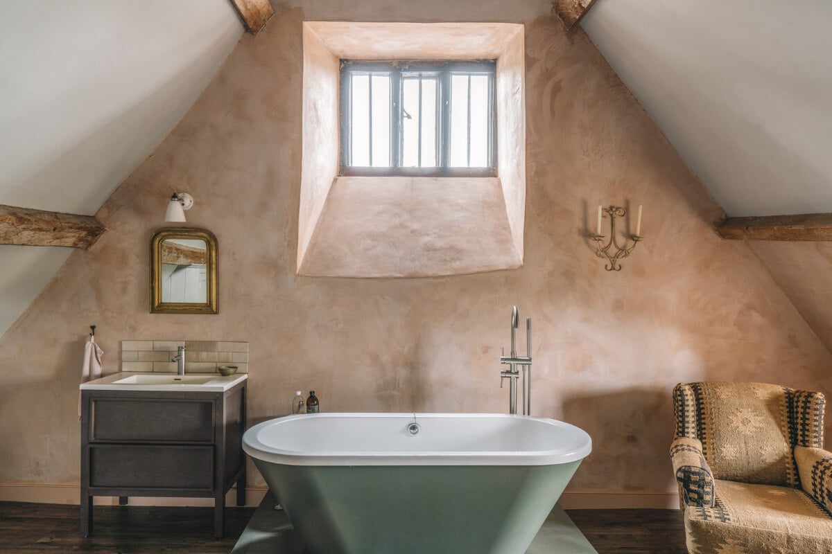 A Beautiful Renovated Country House in England 21 attic bathroom plaster walls freestanding bath