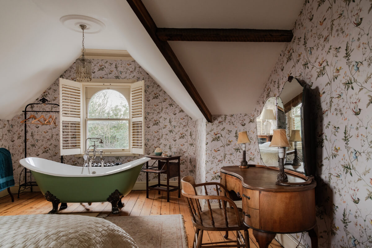 A Grand Victorian Villa in Manchester with Bold Interiors 28 attic bedroom floral wallpaper freestanding bath