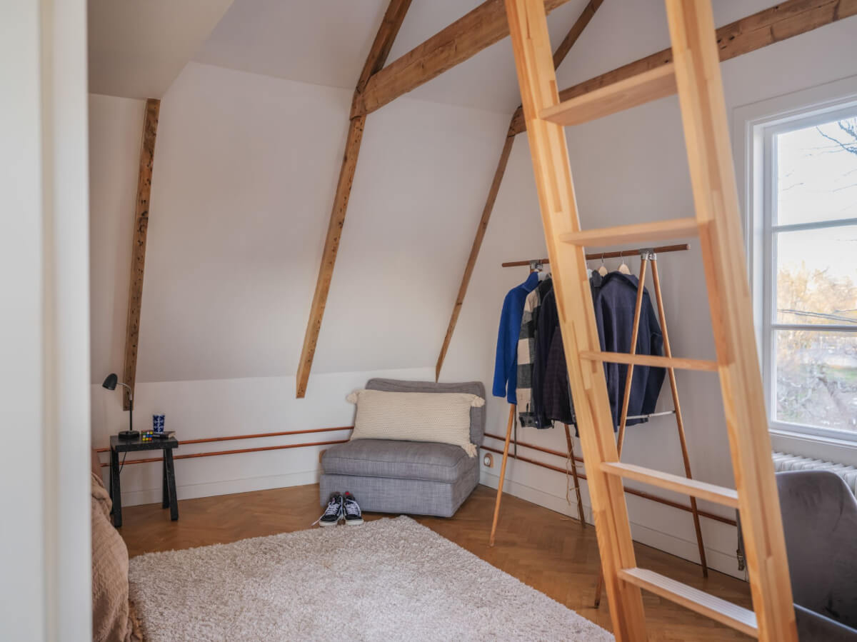 Painted Floorboards in a Unique Family Home in Sweden 26 attic bedroom with clothing rack