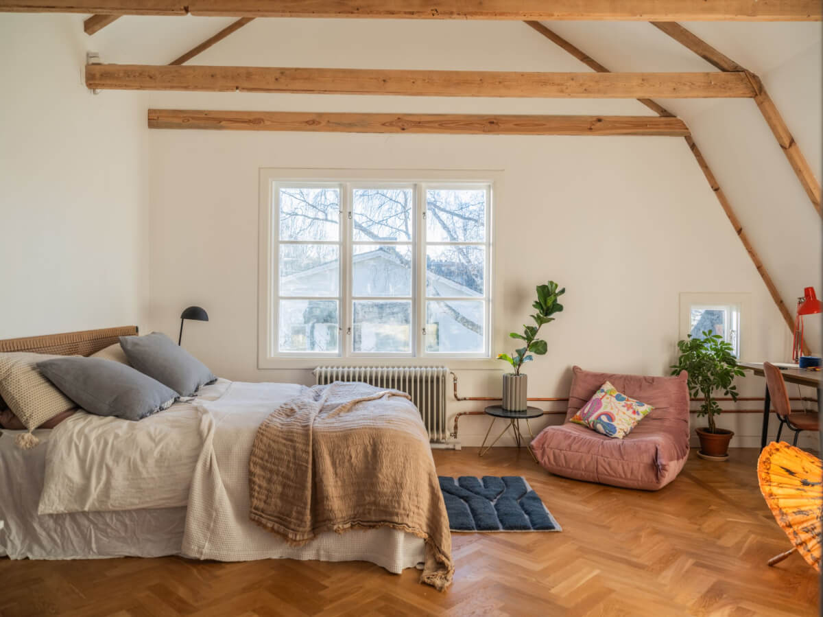 Painted Floorboards in a Unique Family Home in Sweden 21 attic bedroom with parquet floor and wooden beams