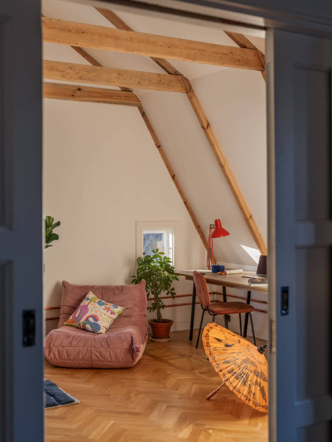 Painted Floorboards in a Unique Family Home in Sweden 20 attic room with desk and exposed wooden beams