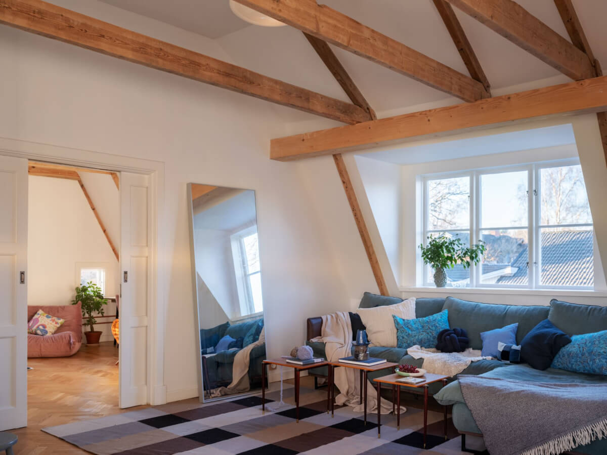 Painted Floorboards in a Unique Family Home in Sweden 18 attic stting room with exposed wooden beams