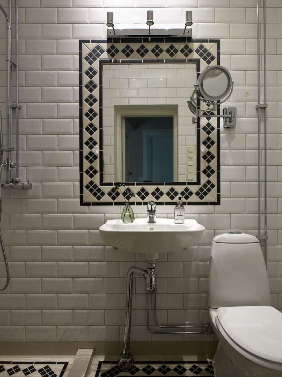 A Grand Early 20th-Century Apartment in Stockholm 24 bathroom black white tiles around mirror
