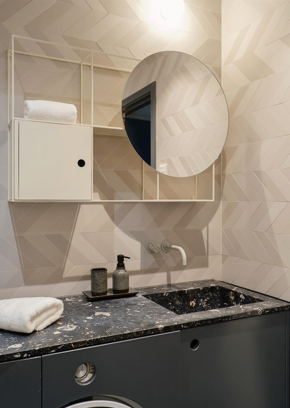 A Small Modern Stockholm Apartment with Smart Storage Solutions 17 bathroom terrazzo sink round mirror chevron patterned tiles