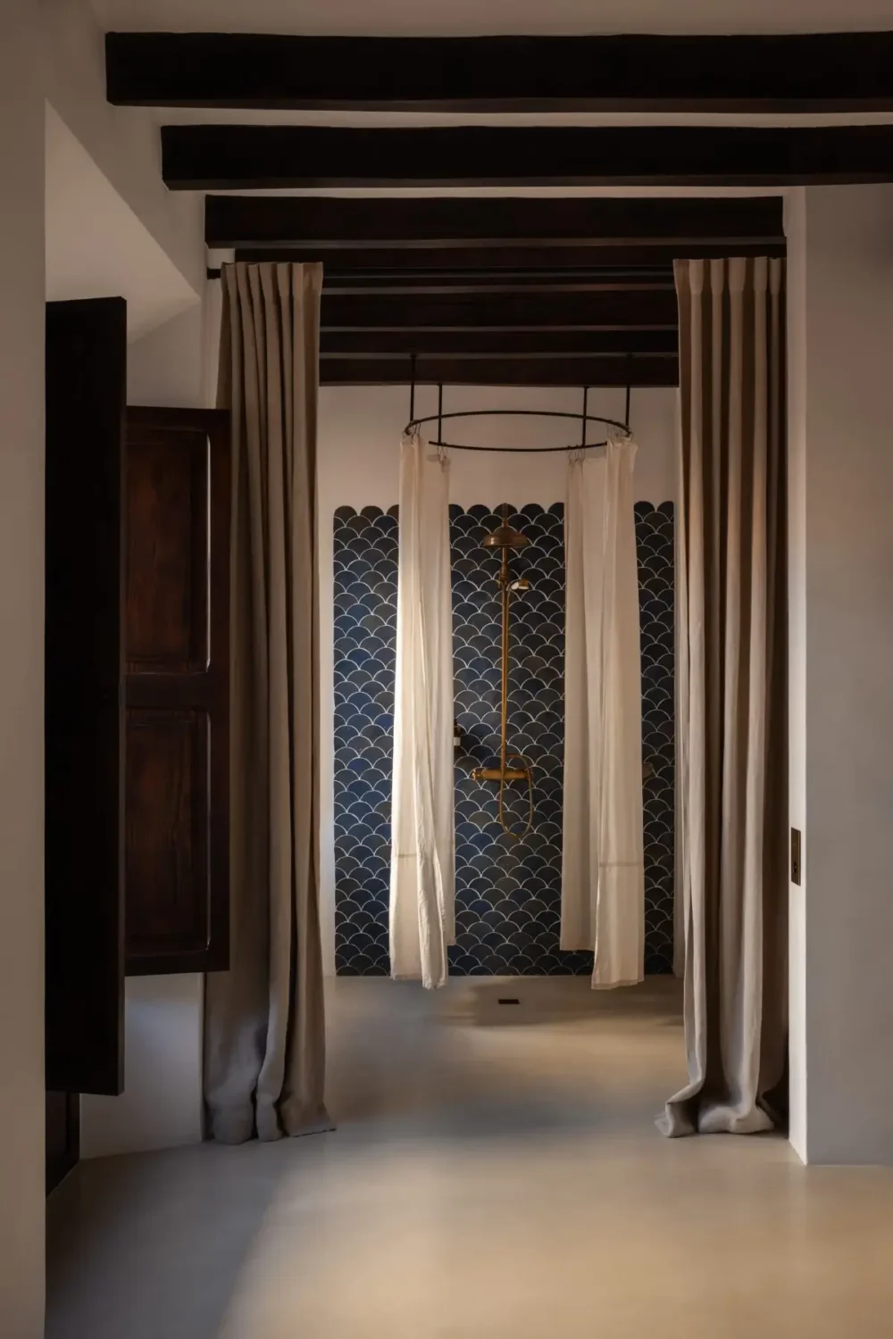 Old-World Craftsmanship and Contemporary Elegance in a Mallorcan Townhouse 10 bathroom with shower with blue tiles and round shower curtain