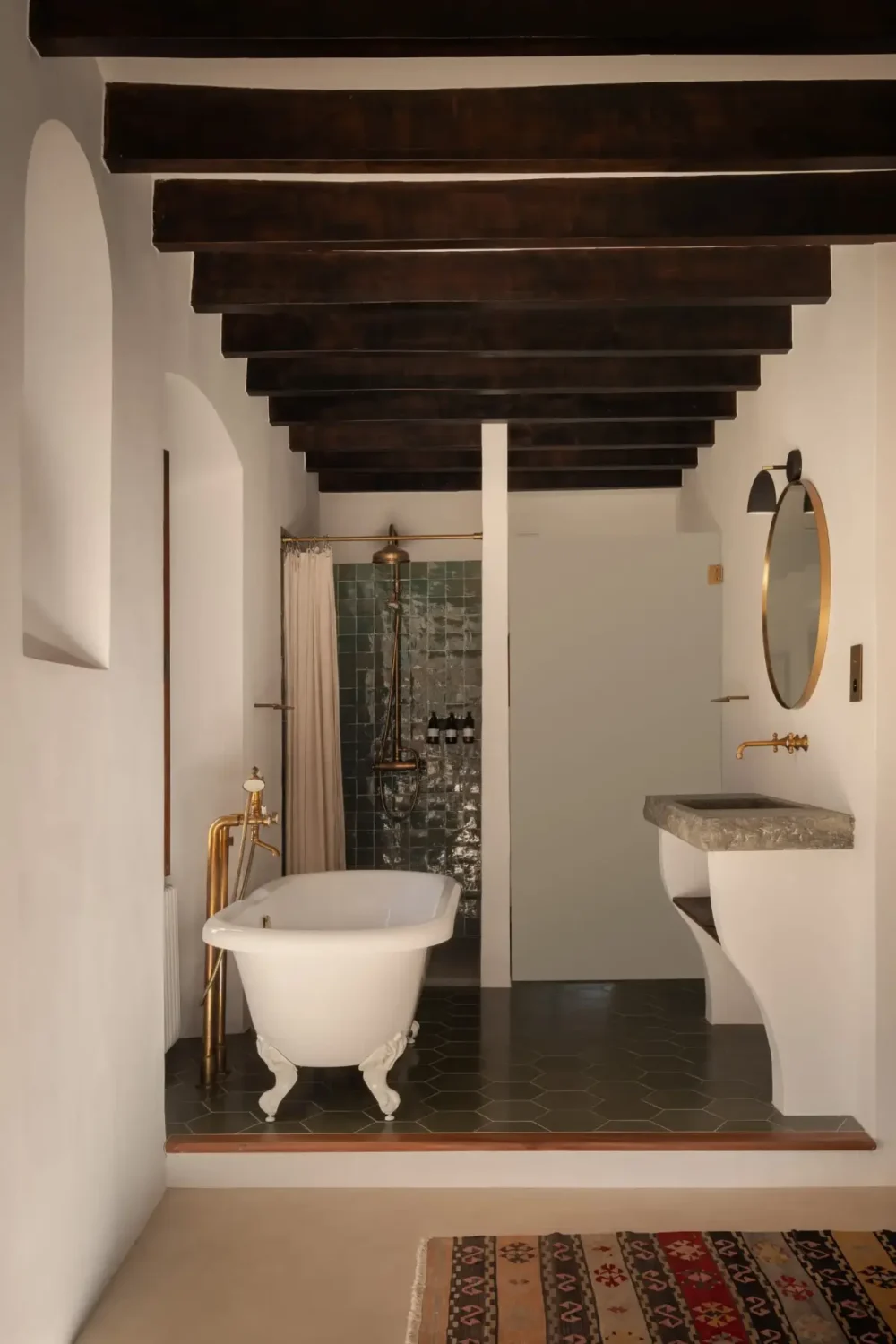 Old-World Craftsmanship and Contemporary Elegance in a Mallorcan Townhouse 8 bathroom wooden beams green shower tiles brass fittings