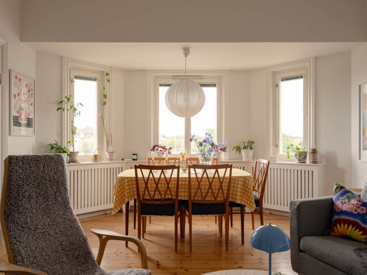 A Small Apartment with High Ceilings and a Large Bay Window 9 bay window with dining table