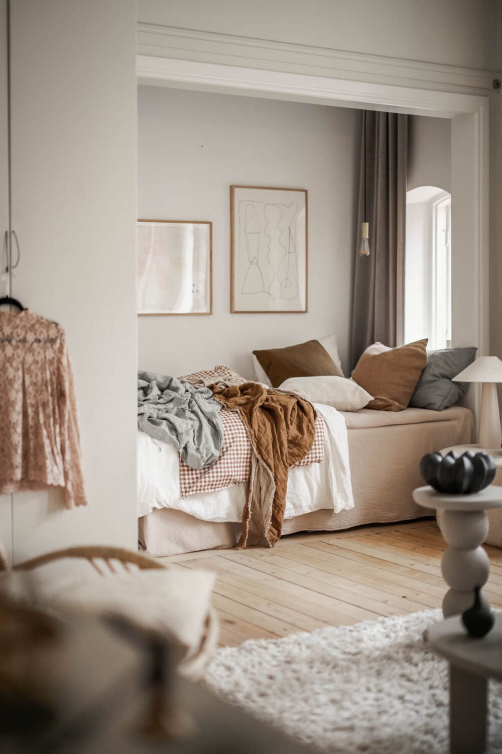 A Stylish Studio Apartment with Period Features and Large Windows 11 bed niche layered textiles