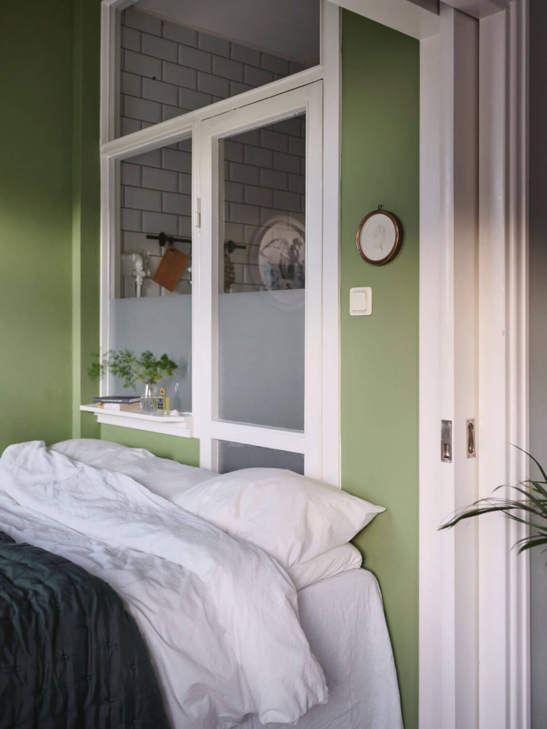 A Small Stockholm Apartment with a Tiny Green Bedroom 14 bed niche with sliding door