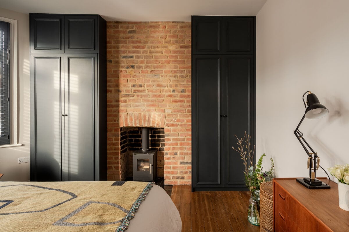 A Restored Victorian House with Exposed Brick and a Kitchen Extension 15 bedroom-brick-fireplace-black-built-in-wardrobes.jpg