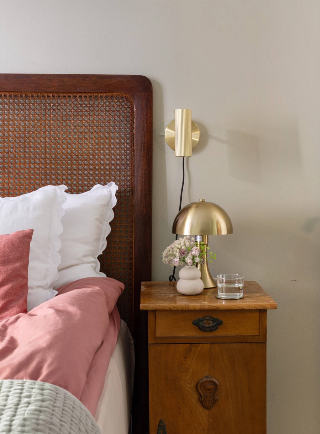 A Charming Ground Floor Apartment with a Large Patio Garden 14 bedroom detail cane headboard vintage nightstand