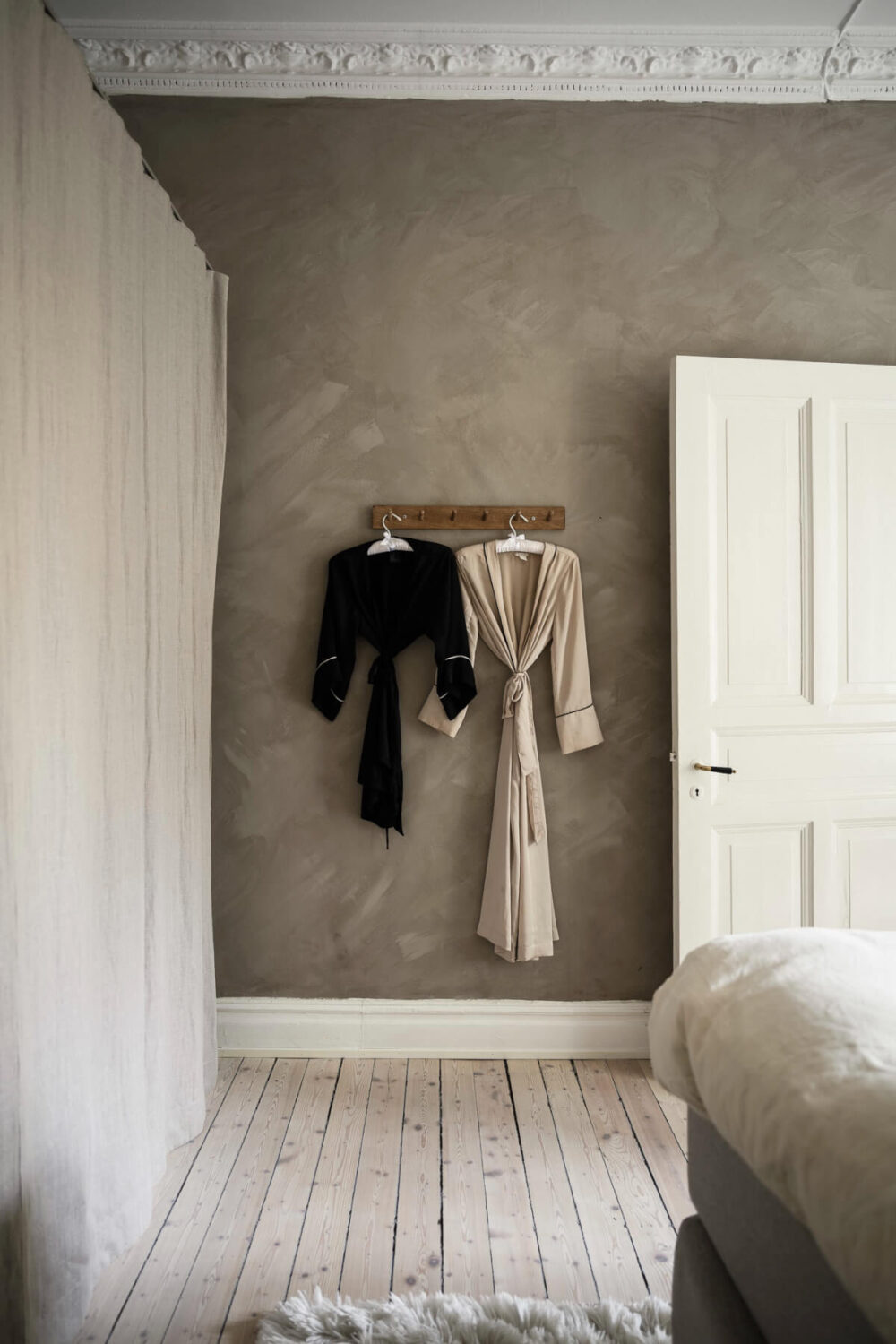 Limewash Wall and Period Features in a Swedish Apartment 19 bedroom wardrobes behind linen curtains