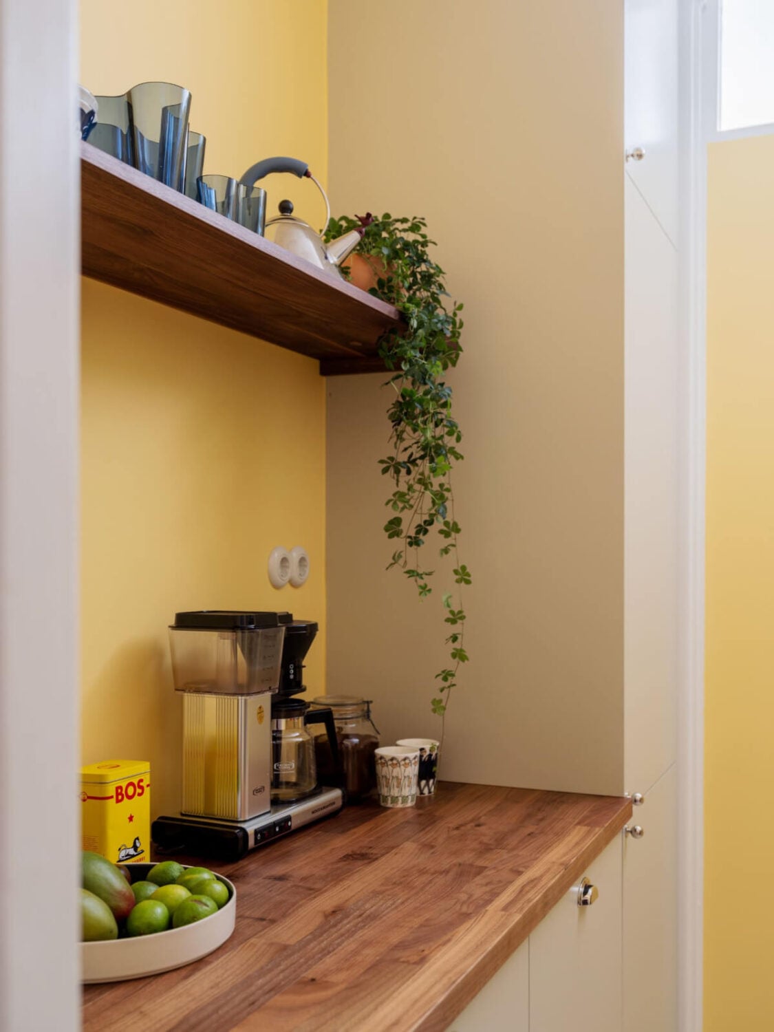 An Airy One-Bedroom Apartment with Art and A Yellow Kitchen 21 beige-gray cabinets wooden countertop