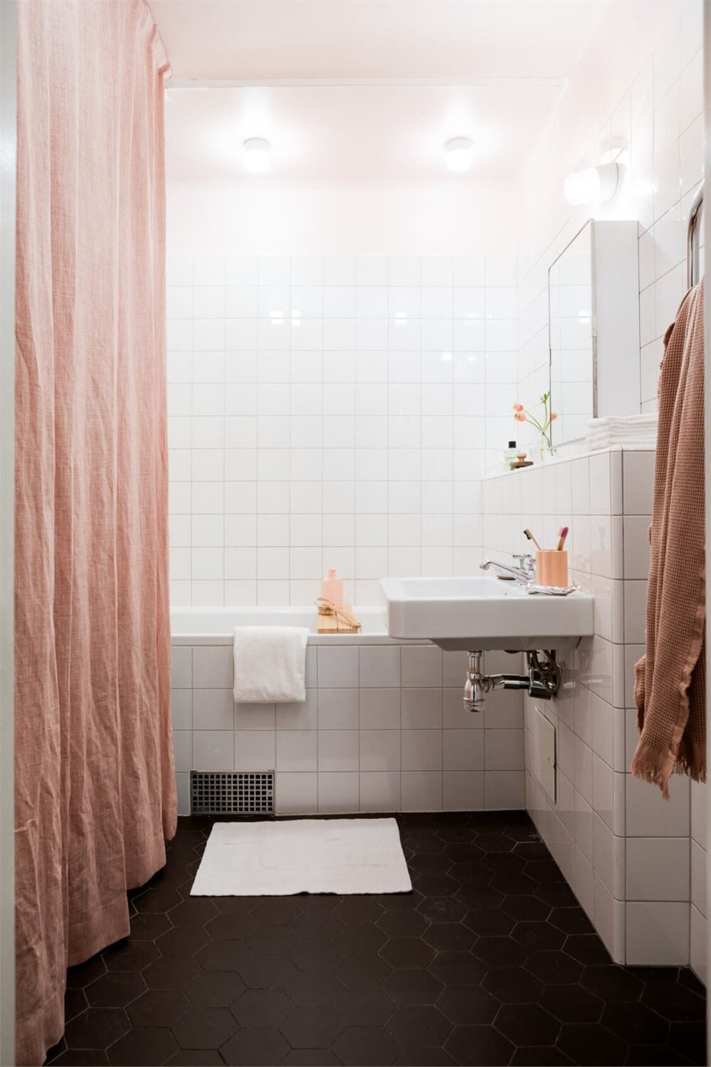 A Light-Filled Two Bedroom Apartment in Stockholm 19 black and white bathroom pink curtain