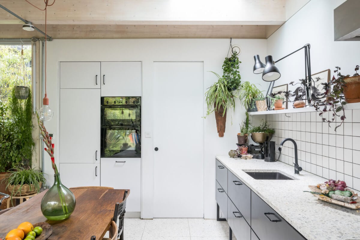 A Unique House in London with Plant-Filled Interiors and a Lush Garden 8 black and white kitchen large wooden dining table