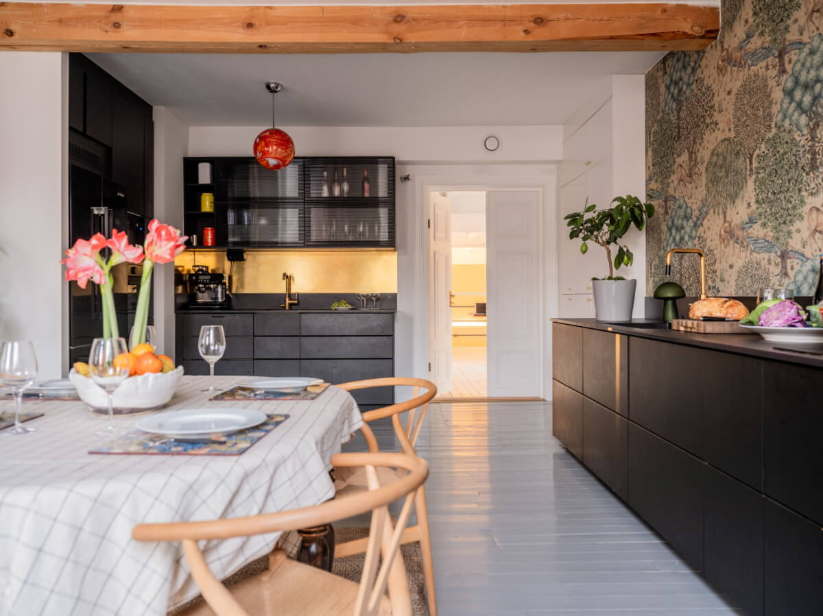 Painted Floorboards in a Unique Family Home in Sweden 9 black kitchen with gray painted floorboards and exposed wooden beam