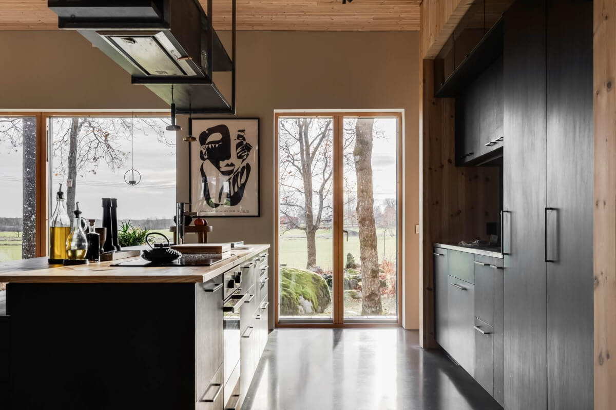 A Swedish Architectural Villa Surrounded by Nature 7 black kitchen with island and large windows