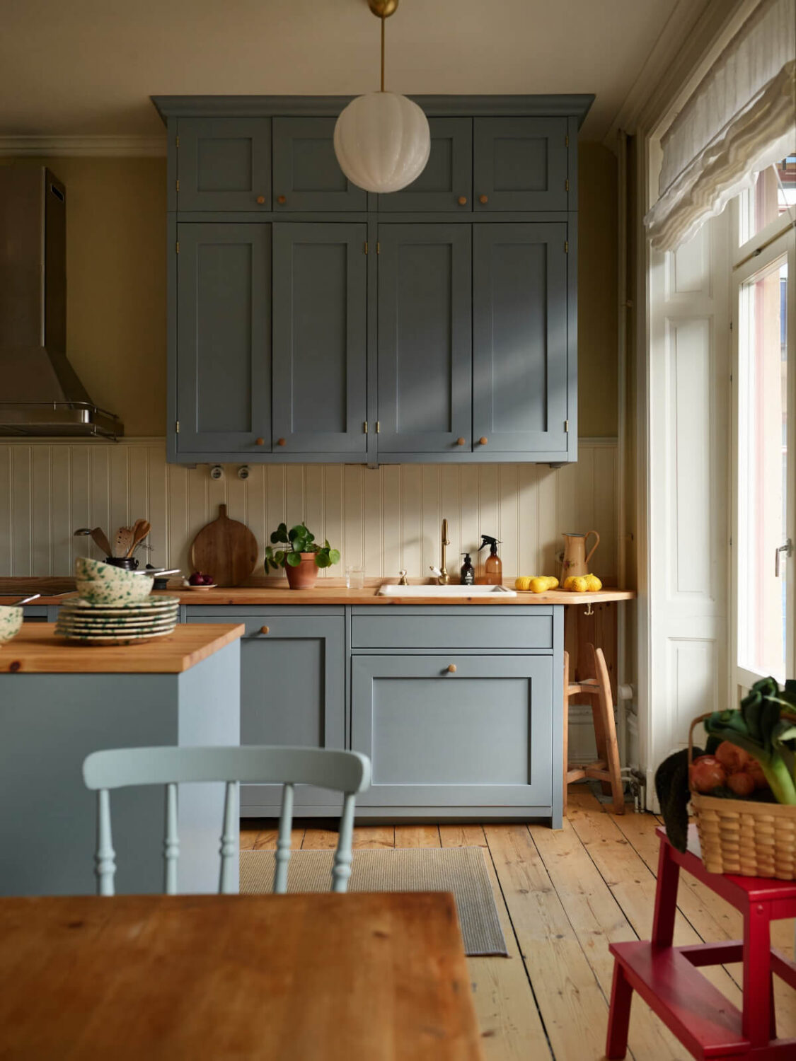 A Charming Historic Stockholm Apartment with a Blue Kitchen 3 blue kitchen wood paneling backsplash