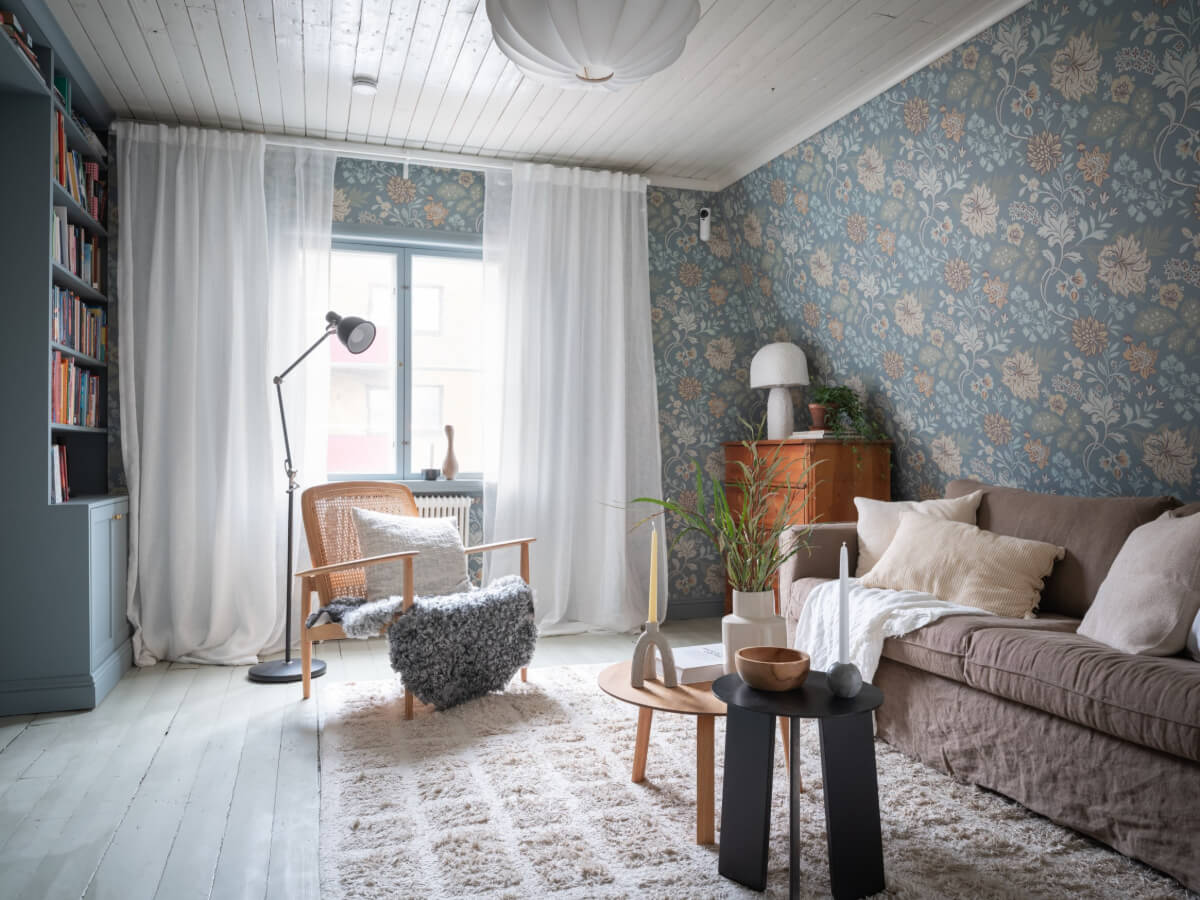 A Carefully Renovated Family Home in Sweden 1 blue living room with slanted ceiling and floral wallpaper