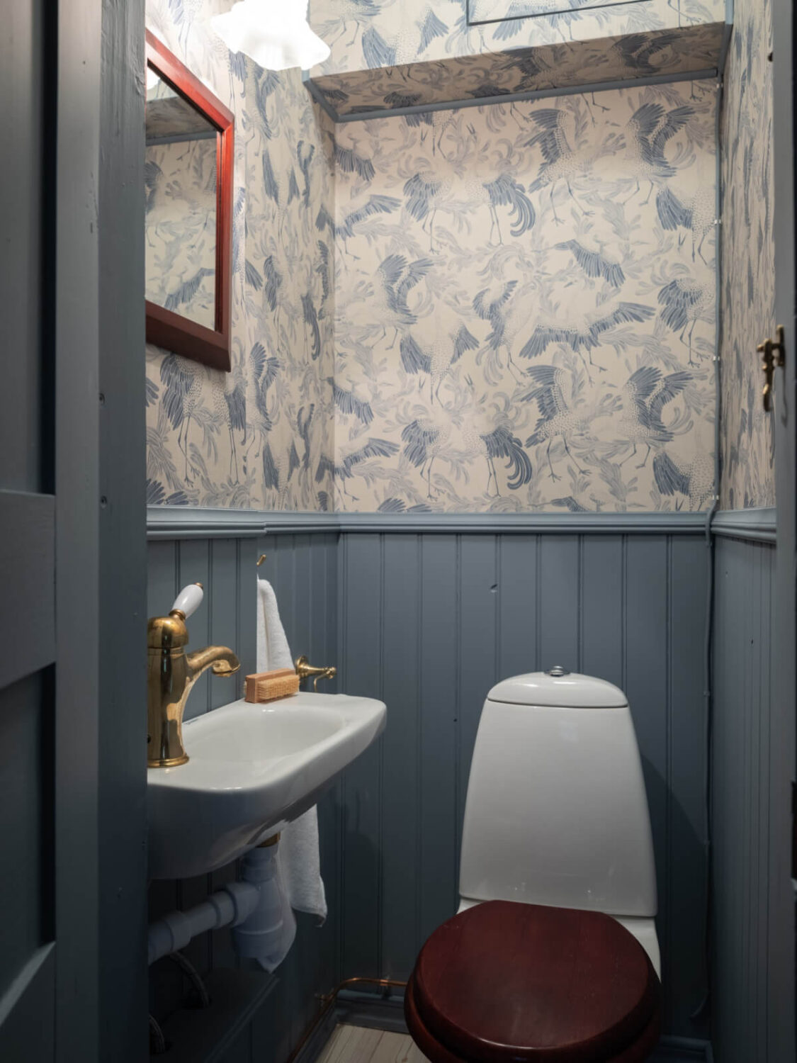 A Carefully Renovated Family Home in Sweden 24 blue powder room with wallpaper