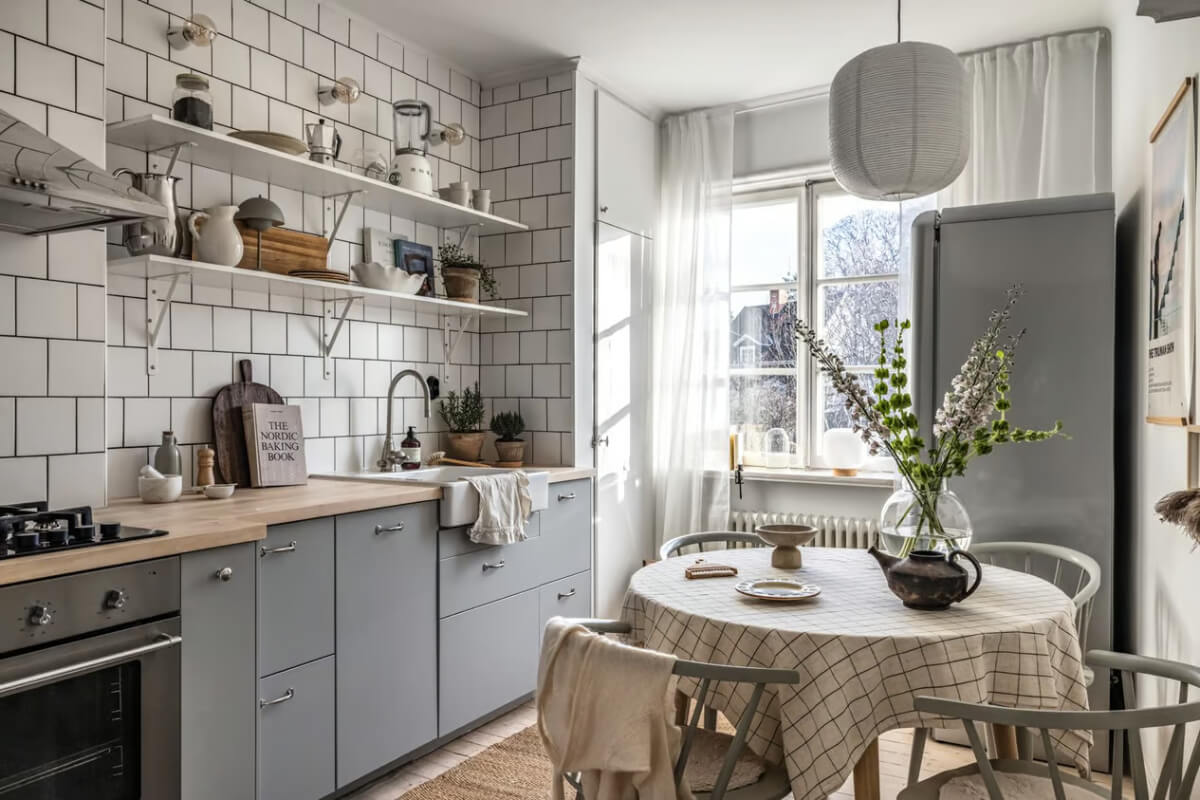 A Beige Studio Apartment with a Bright Kitchen 6 bright kitchen gray cabinets wooden worktop white tiles and shelves