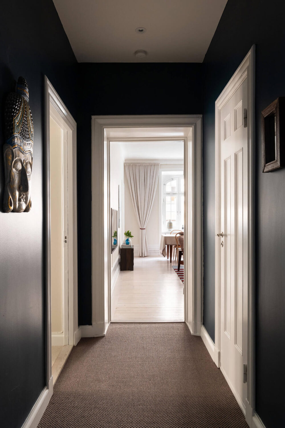 Contrasting Colors in a Turn-of-the-Century Apartment in Stockholm 20 dark blue hall view into living room Contrasting Colors in a Turn-of-the-Century Apartment in Stockholm