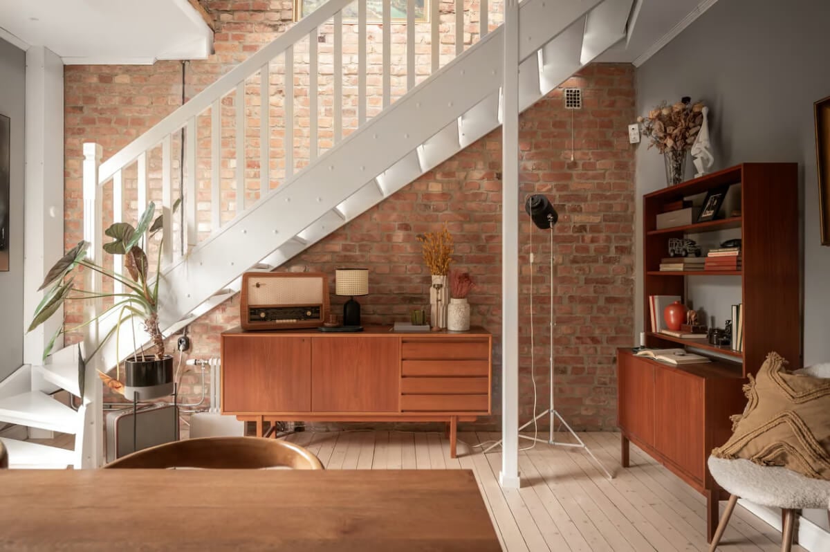 A Swedish Attic Apartment with Exposed Brick and Yellow Color Accents 4 dining room exposed brick wall midcentury furniture