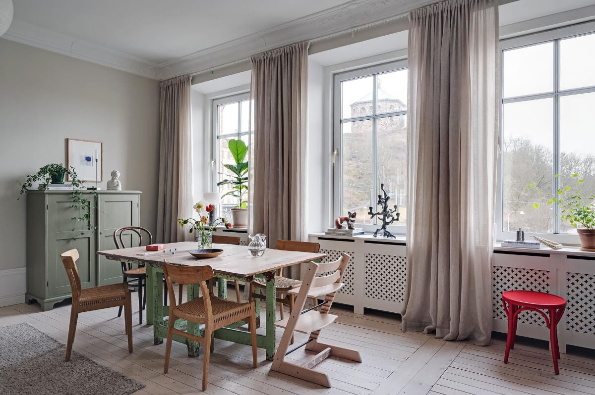 Period Features and Modern Materials in a Swedish Apartment 9 dining table in front of windo