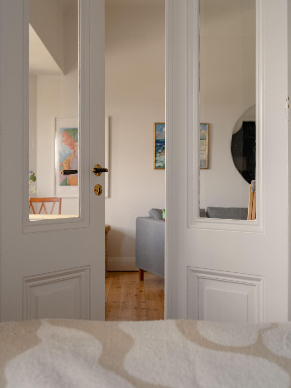 A Small Apartment with High Ceilings and a Large Bay Window 14 double doors view into living room