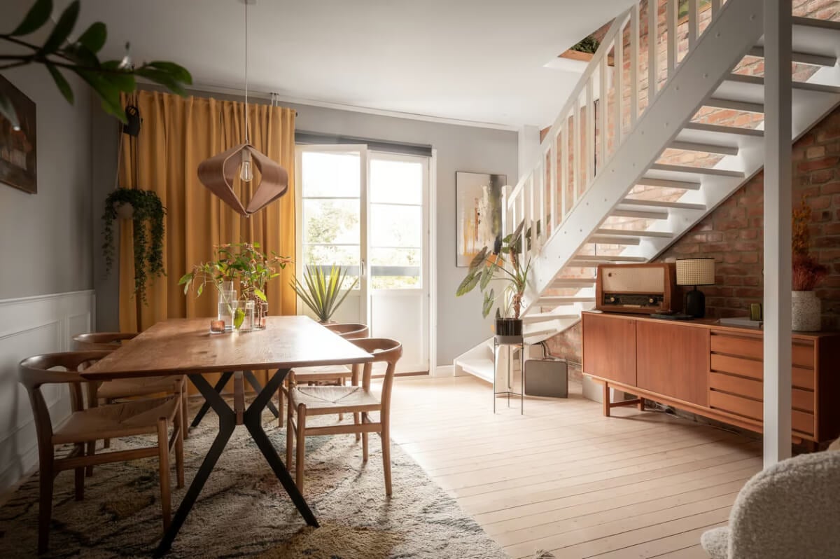 gray dining room wooden floorboards exposed brick wall yellow curtains